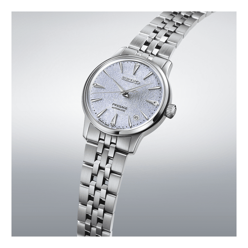 Silver wristwatch with a detailed face on a light gray background